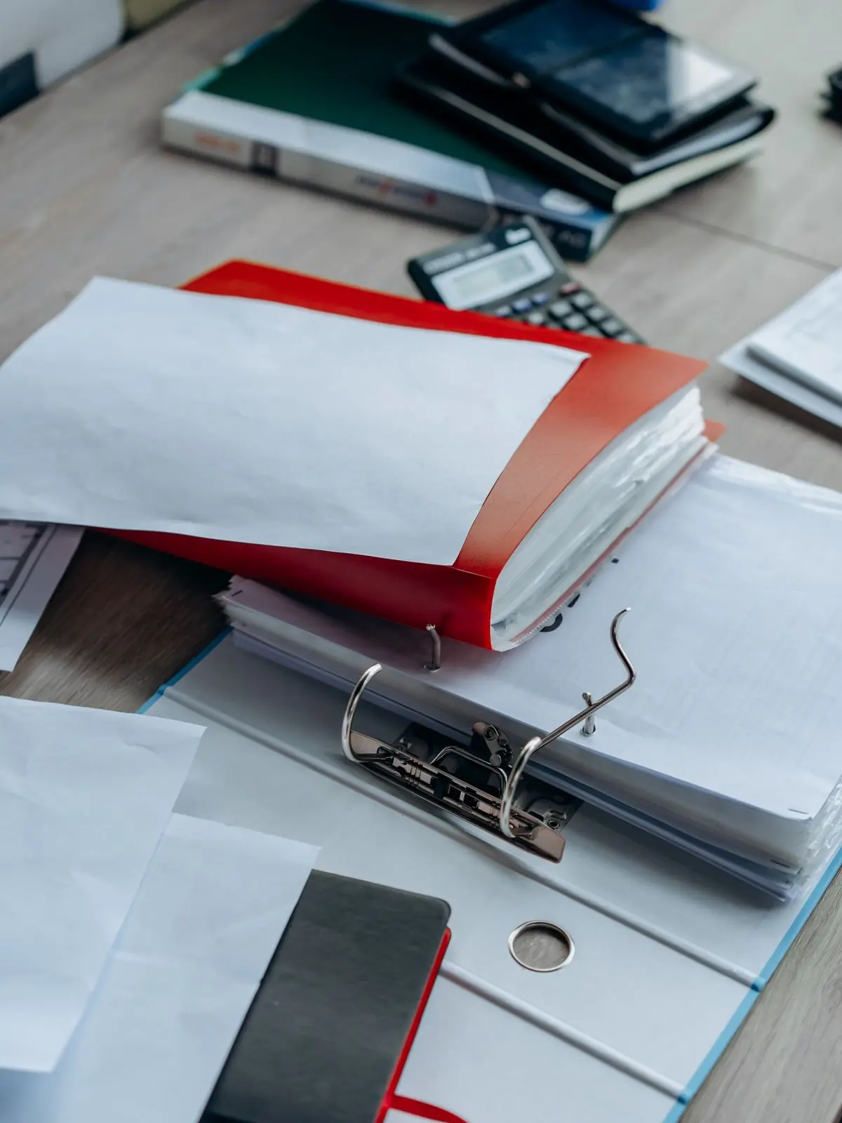 Archivador y carpetas con documentos sobre una mesa de trabajo